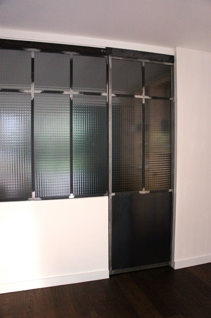 Porte coulissante en acier atelier d'artiste et verrière avec verre armé grande maille Porte coulissante en acier atelier d'artiste et verrière avec verre armé grande maille